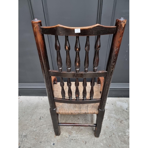 1084 - An unusually small 19th century ash and rush spindle back armchair.