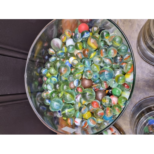 1159 - A large quantity of glass marbles, in five clear glass vases, (largest cracked).