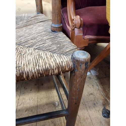 1083 - An antique ash and rush seated Sussex style elbow chair, with ladder back.