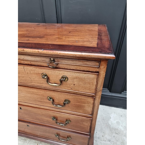 1053 - A small George III mahogany and crossbanded four drawer chest, with brushing slide, 87cm wide.... 