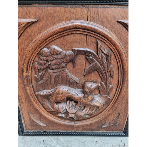 1008 - A pair of carved oak relief panels, of a dog and fox, in ebonized frames, the whole 57 x 53cm.&... 