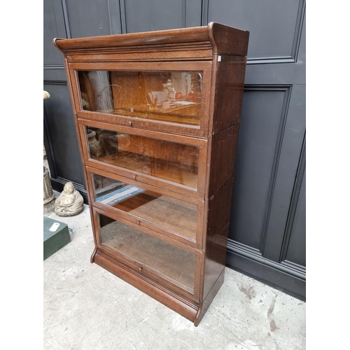 1027 - An early 20th century oak four tier sectional bookcase, in the Globe Wernicke style, 142cm high x 86... 