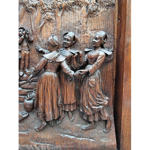 1033 - A Black Forest style carved oak relief panel of figures merrymaking, in oak frame, the whole 50.5 x ... 