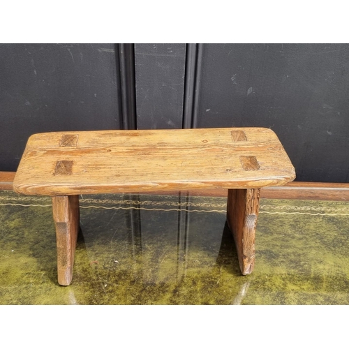 1051 - An antique pine milking stool, 20.5cm high x 38cm wide.