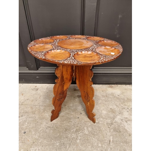 1061 - An Indian carved hardwood low circular table, with dished top, 56cm diameter.