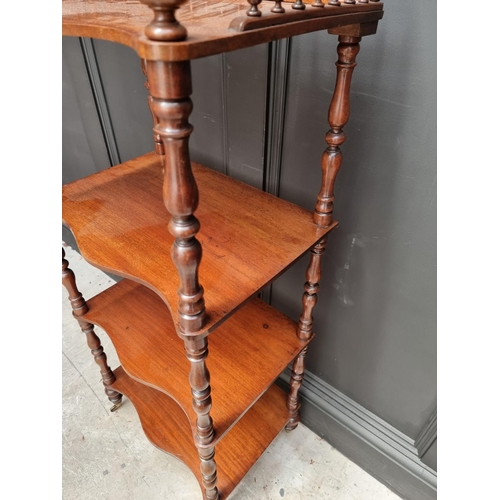 1065 - A Victorian mahogany serpentine fronted four tier whatnot, 47.5cm wide. 