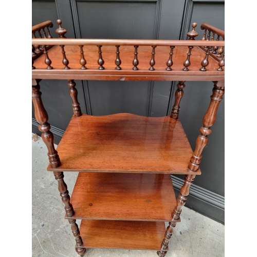 1065 - A Victorian mahogany serpentine fronted four tier whatnot, 47.5cm wide. 