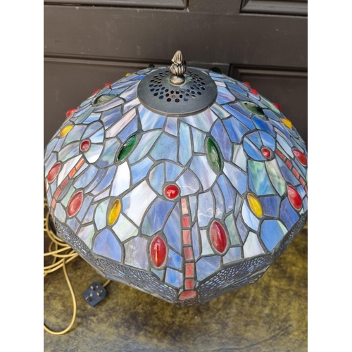 1066 - A bronzed, stained and leaded glass table lamp, 57cm high.