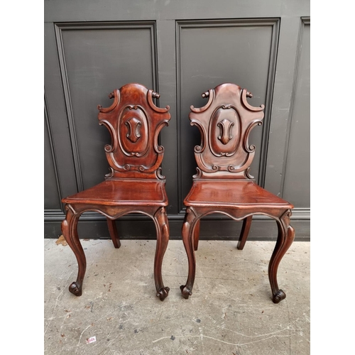 1085 - A pair of Victorian carved mahogany hall chairs. 