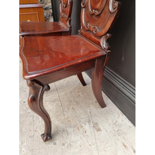 1085 - A pair of Victorian carved mahogany hall chairs. 