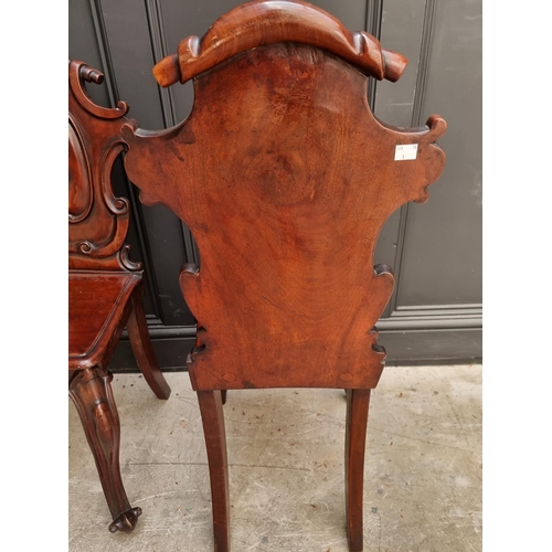 1085 - A pair of Victorian carved mahogany hall chairs. 