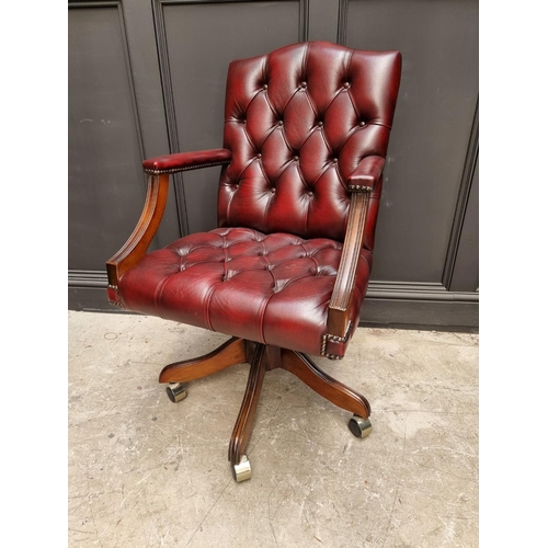 1087 - A modern red buttoned leather desk chair. 