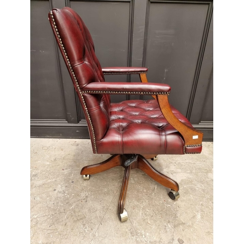 1087 - A modern red buttoned leather desk chair. 