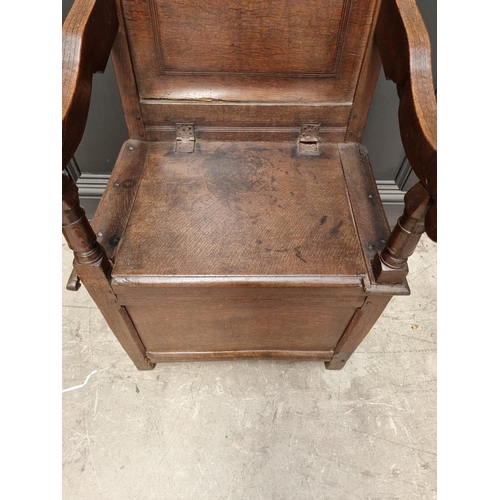 1098 - A 17th century panelled oak box seat open armchair, 106.5cm high x 60cm wide.  ... 