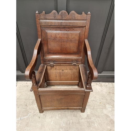 1098 - A 17th century panelled oak box seat open armchair, 106.5cm high x 60cm wide.  ... 