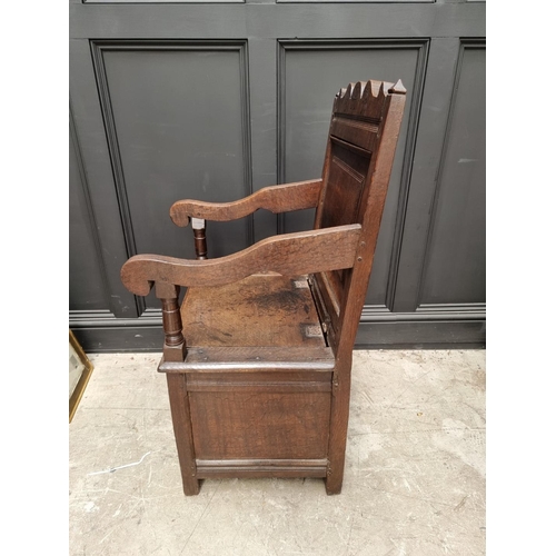 1098 - A 17th century panelled oak box seat open armchair, 106.5cm high x 60cm wide.  ... 