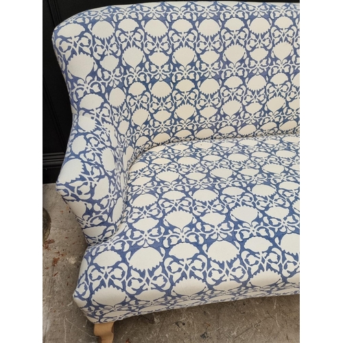 1099 - A contemporary blue and white upholstered settee, 175cm wide. 