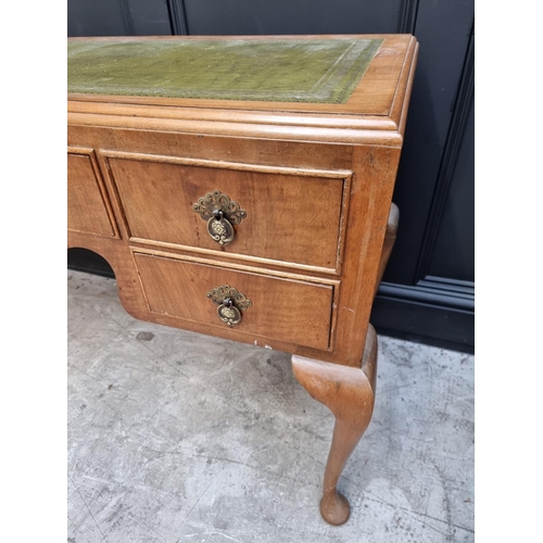 1106 - A 1930s walnut desk, with green leather inset surface and cabriole legs, 118.5cm wide.... 