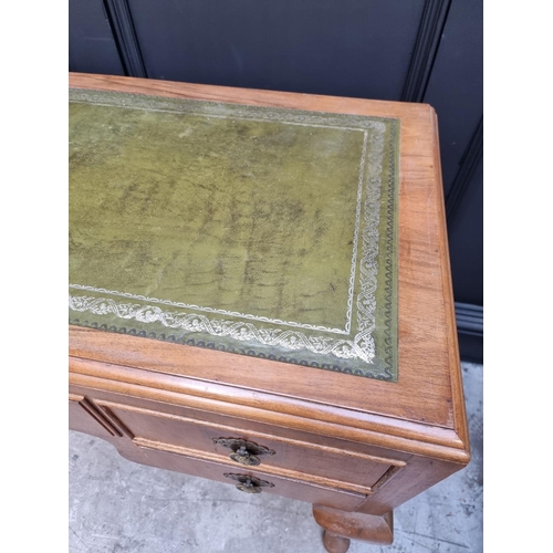 1106 - A 1930s walnut desk, with green leather inset surface and cabriole legs, 118.5cm wide.... 