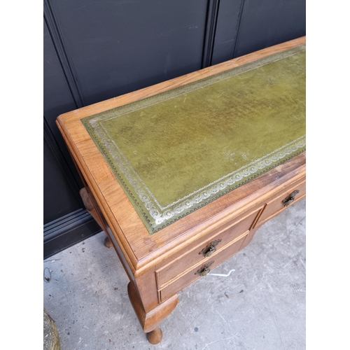 1106 - A 1930s walnut desk, with green leather inset surface and cabriole legs, 118.5cm wide.... 