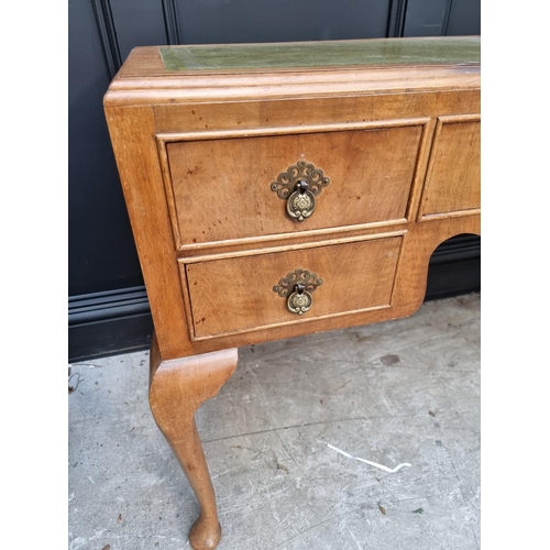 1106 - A 1930s walnut desk, with green leather inset surface and cabriole legs, 118.5cm wide.... 