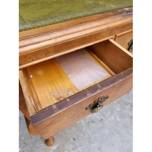 1106 - A 1930s walnut desk, with green leather inset surface and cabriole legs, 118.5cm wide.... 