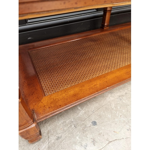 1110 - A modern mahogany, glass and rattan low occasional table, 129.5cm wide.