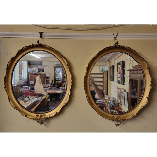 1129 - A pair of antique gilt framed oval wall mirrors, 66 x 53cm, (s.d. to mouldings).