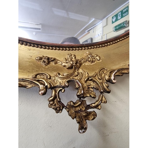 1129 - A pair of antique gilt framed oval wall mirrors, 66 x 53cm, (s.d. to mouldings).