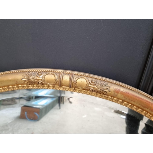 1130 - A 19th century gilt framed oval wall mirror, with anthemion decoration, 60 x 85cm. ... 