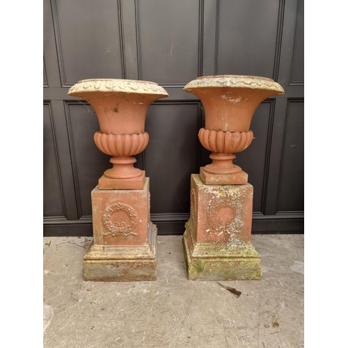 1136 - A large pair of red painted composition stone Campana urns and pedestals, total height 128cm.&n... 