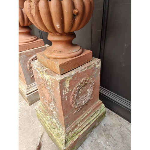 1136 - A large pair of red painted composition stone Campana urns and pedestals, total height 128cm.&n... 