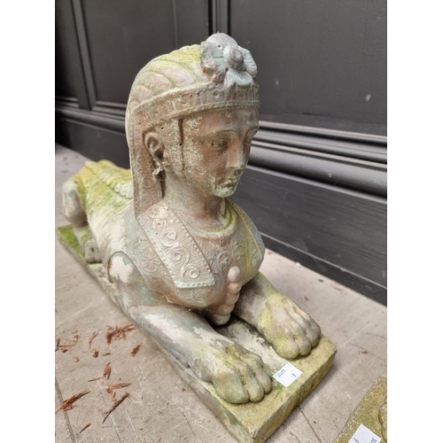 1142 - A pair of composition stone sphinxes, 48cm long.