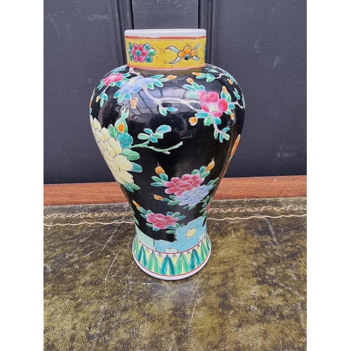 1375 - A Chinese famille rose black ground vase and cover, 30.5cm high. 