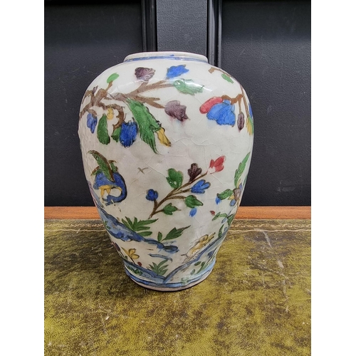 1396 - An Iznik pottery ovoid vase, painted with birds in flowering branches, 26cm high, (s.d.).... 