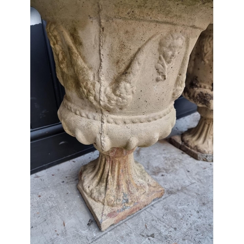 1150 - A pair of composition stone urns, 53cm high, (s.d. to each). 