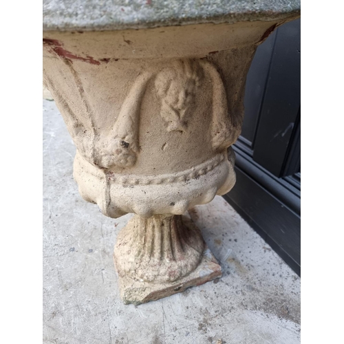 1150 - A pair of composition stone urns, 53cm high, (s.d. to each). 