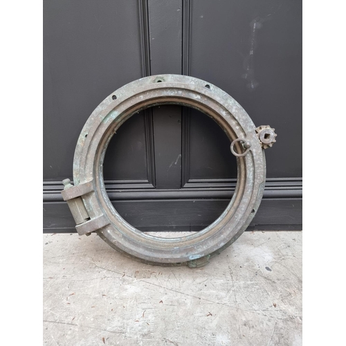 1165 - A bronze ship's porthole, 49cm diameter, (in salvaged condition).