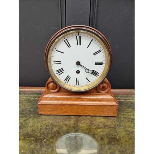 1183 - A Victorian oak drumhead timepiece, 26cm high, with pendulum.