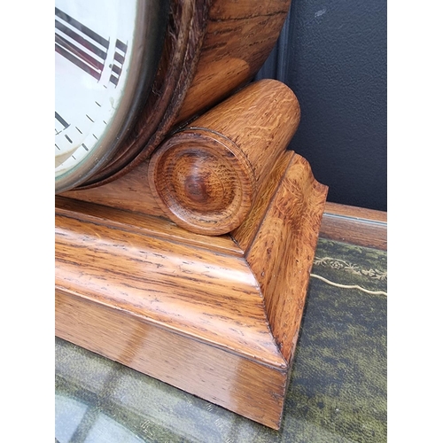 1183 - A Victorian oak drumhead timepiece, 26cm high, with pendulum.