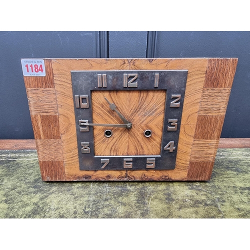 1184 - An Art Deco figured walnut and oak mantel clock, 29.5cm diameter, with pendulum.