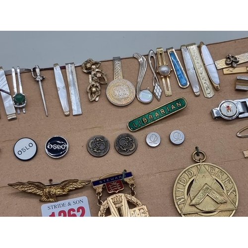 1262 - A collection of tie pins and badges. 