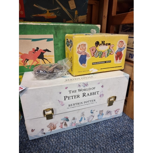 32 - A mixed group of toys and pastimes: to include, a boxed set of Peter Rabbit books; two Pelham Puppet... 