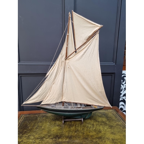 75 - A painted wood pond yacht, total length 83.5cm, on wood stand