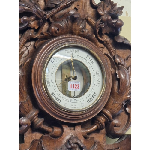 1123 - A large carved oak aneroid barometer, 78cm high. 