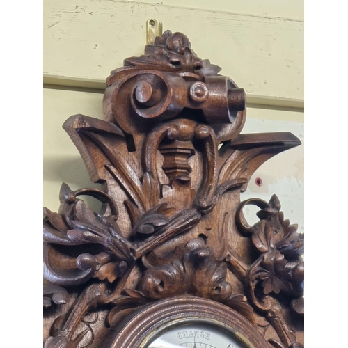 1123 - A large carved oak aneroid barometer, 78cm high. 