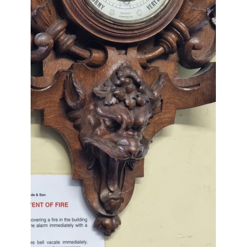 1123 - A large carved oak aneroid barometer, 78cm high. 