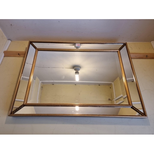 1128 - A reproduction gilt framed rectangular wall mirror, 53 x 73cm.