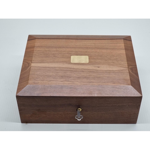 1498 - A walnut cigar humidor, 28cm wide; together with two Zippo lighters; a black leather cigar slee... 