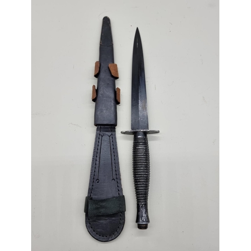 1597 - A Fairbairn Sykes style fighting knife and leather sheath, with 17.5cm blade.